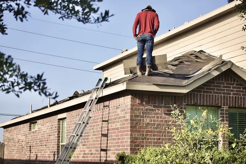 Professional roofer working on a residential roof in East Granby